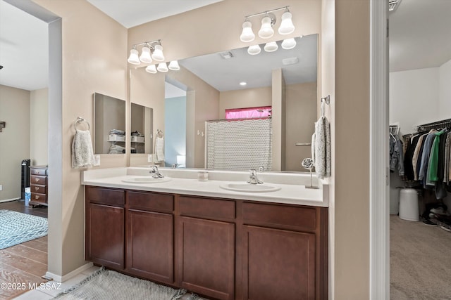 33743 S Ballad Dr, Red Rock, AZ 85145 - bathroom with a shower with shower curtain, double vanity, a sink, and wood finished floors