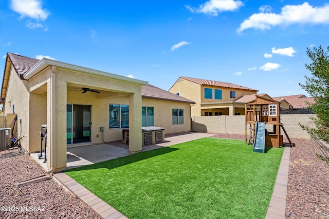 33743 S Ballad Dr, Red Rock, AZ 85145 - back of house with a fenced backyard, stucco siding, a lawn, a patio, and a playground
