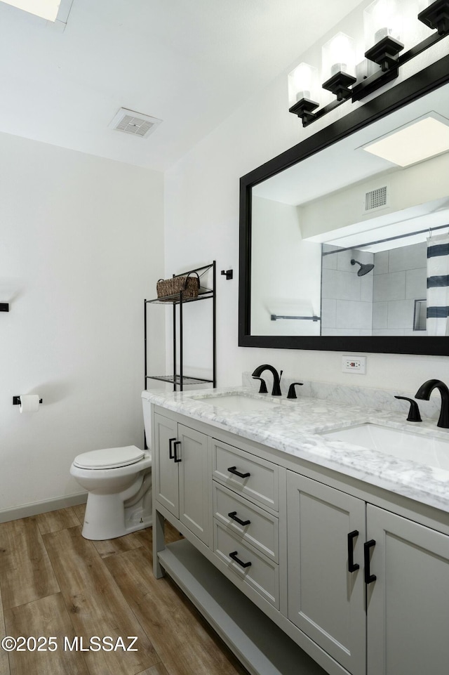 2301 W Montrose Pl, Tucson, AZ 85741 - full bath with double vanity, wood finished floors, a sink, toilet, and a shower with shower curtain