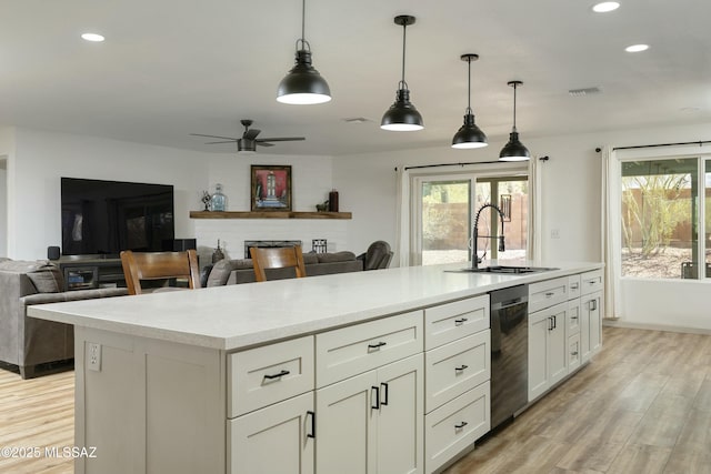 2301 W Montrose Pl, Tucson, AZ 85741 - kitchen with a kitchen island with sink, visible vents, stainless steel dishwasher, a sink, and light countertops