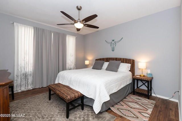 bedroom with multiple windows, wood finished floors, and a ceiling fan