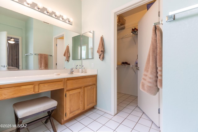 full bathroom with a spacious closet, visible vents, vanity, and tile patterned flooring