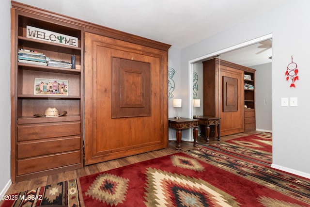interior space with wood finished floors and baseboards
