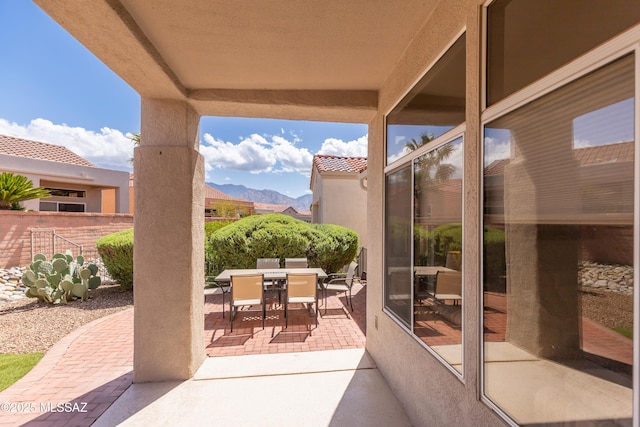 view of patio / terrace with a mountain view, outdoor dining area, and fence