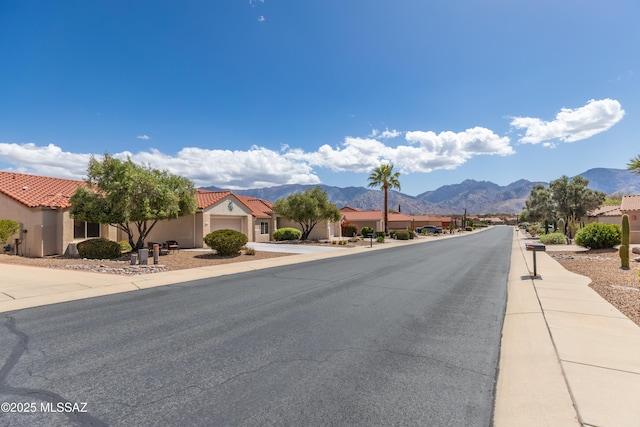 view of road featuring sidewalks and a mountain view