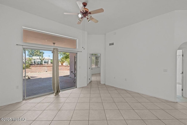 spare room with visible vents, arched walkways, a ceiling fan, and plenty of natural light