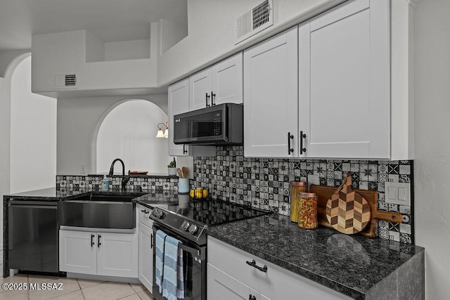 kitchen featuring arched walkways, electric range, black microwave, a sink, and visible vents
