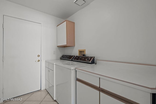 laundry room featuring cabinet space, light tile patterned flooring, and independent washer and dryer