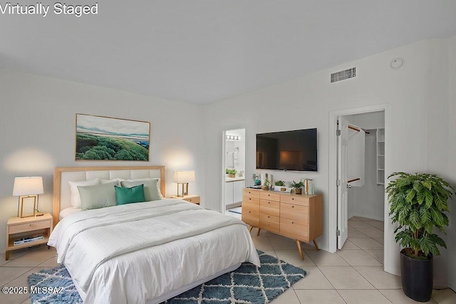 bedroom with light tile patterned floors, visible vents, and a spacious closet