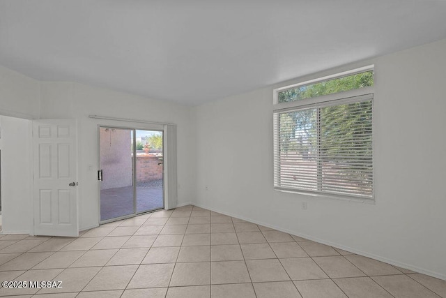 empty room with light tile patterned floors and baseboards