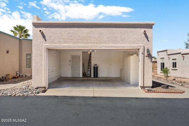 view of front facade featuring driveway, a garage, and stucco siding