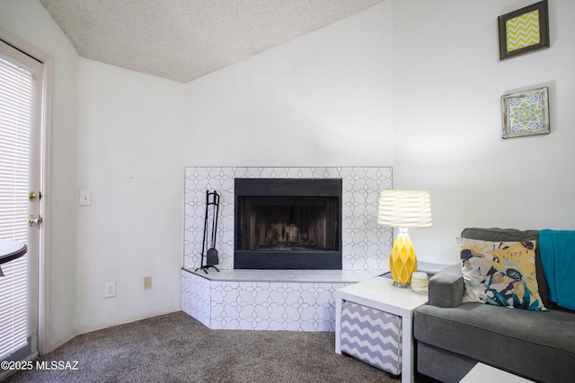 living room featuring lofted ceiling, a fireplace, carpet flooring, and a textured ceiling