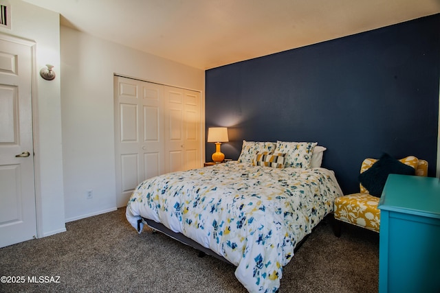 carpeted bedroom featuring baseboards and a closet