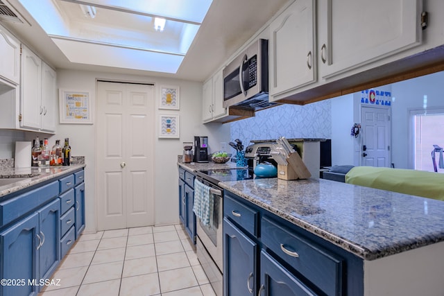kitchen with white cabinetry, light tile patterned flooring, stainless steel appliances, and blue cabinets