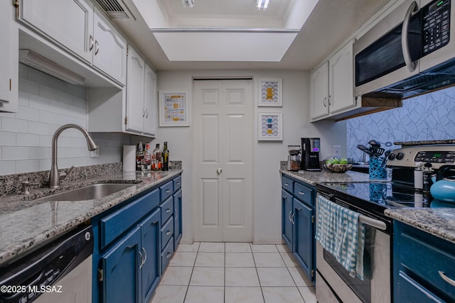 kitchen with blue cabinetry, white cabinets, a sink, and stainless steel appliances