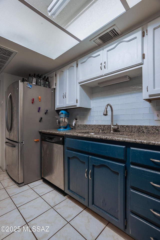 kitchen with backsplash, a sink, blue cabinets, appliances with stainless steel finishes, and visible vents
