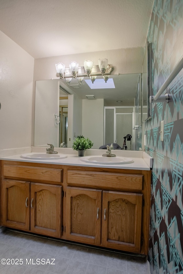 full bath with tile patterned flooring, a sink, a stall shower, and double vanity