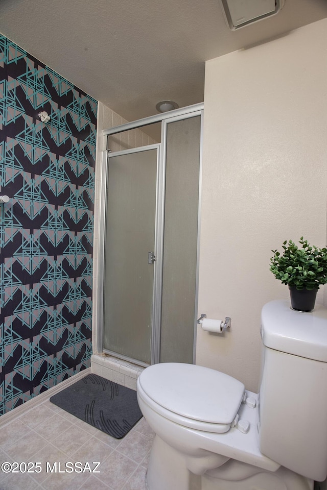 bathroom with toilet, tile patterned floors, and a stall shower