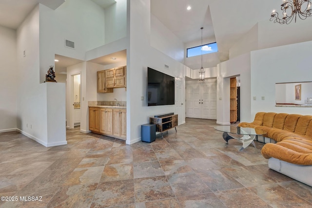 6091 N Golden Eagle Dr, Tucson, AZ 85750 - living room with visible vents, baseboards, a notable chandelier, and a high ceiling