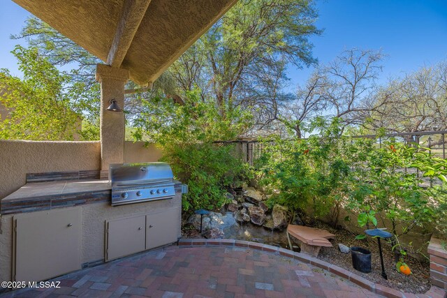 6091 N Golden Eagle Dr, Tucson, AZ 85750 - view of patio featuring grilling area, a fenced backyard, and an outdoor kitchen