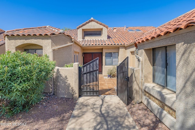 6091 N Golden Eagle Dr, Tucson, AZ 85750 - mediterranean / spanish house with fence, stucco siding, a tiled roof, and a gate