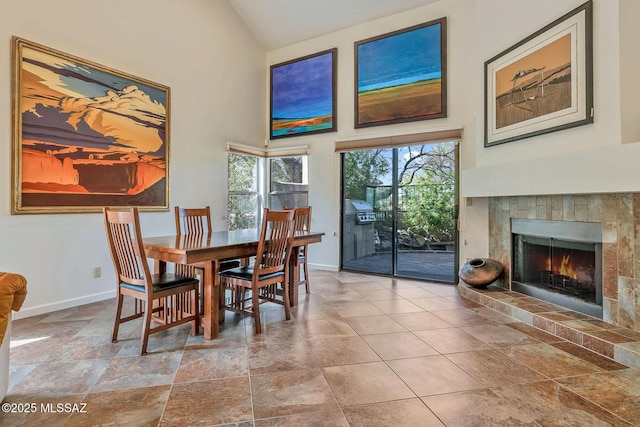 6091 N Golden Eagle Dr, Tucson, AZ 85750 - dining space featuring a tile fireplace, high vaulted ceiling, and baseboards