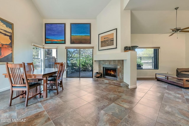 6091 N Golden Eagle Dr, Tucson, AZ 85750 - dining area featuring a tiled fireplace, baseboards, high vaulted ceiling, and a ceiling fan