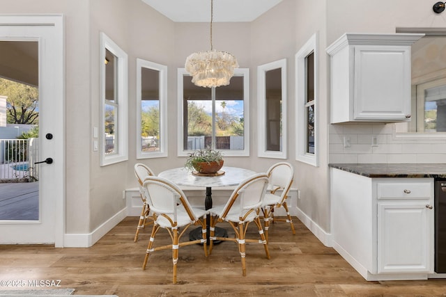 dining area with a wealth of natural light, a chandelier, and light wood-type flooring