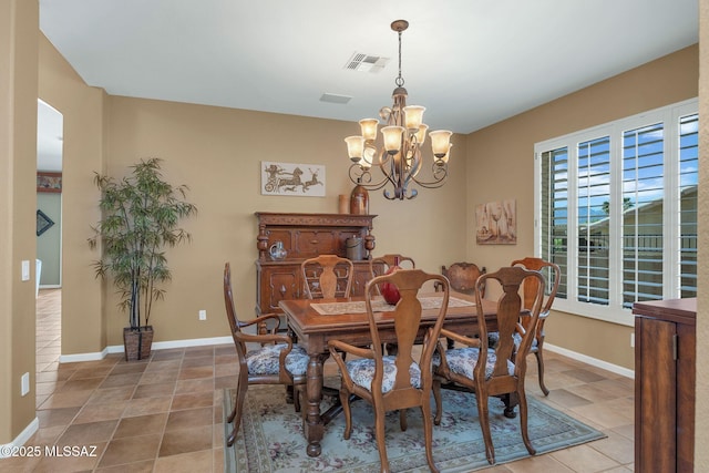 tiled dining space with an inviting chandelier, visible vents, and baseboards