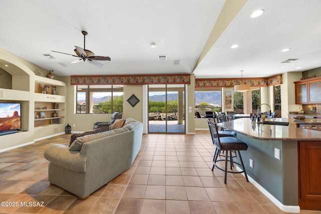 living area featuring light tile patterned floors, visible vents, baseboards, recessed lighting, and built in shelves