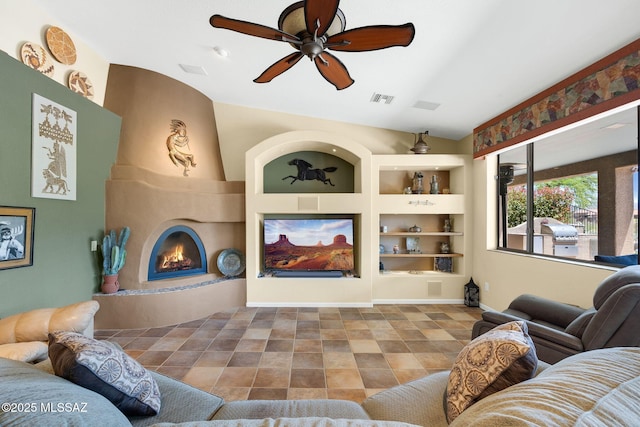 tiled living area featuring a large fireplace, visible vents, a ceiling fan, and built in shelves