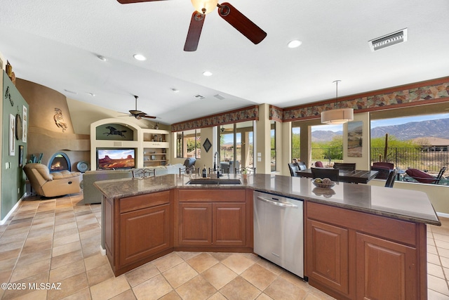 kitchen with stainless steel dishwasher, vaulted ceiling, a sink, visible vents, and a ceiling fan