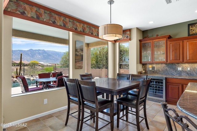 dining room featuring recessed lighting, indoor wet bar, a mountain view, baseboards, and wine cooler
