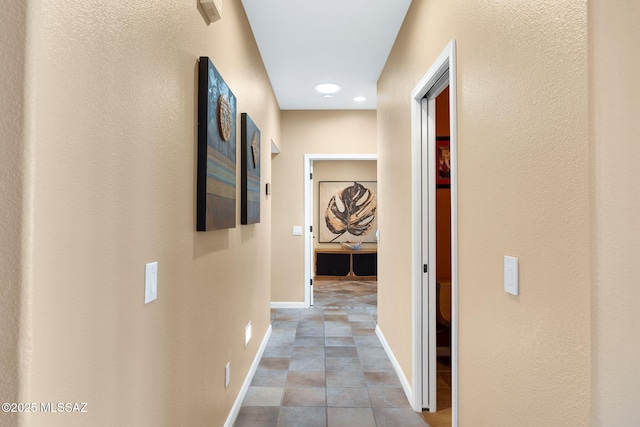 hallway with recessed lighting and baseboards