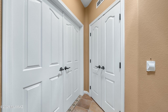interior space featuring visible vents and a textured wall