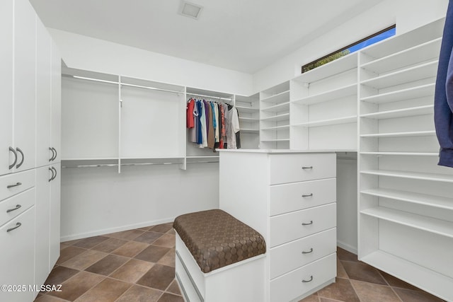 walk in closet with stone finish flooring