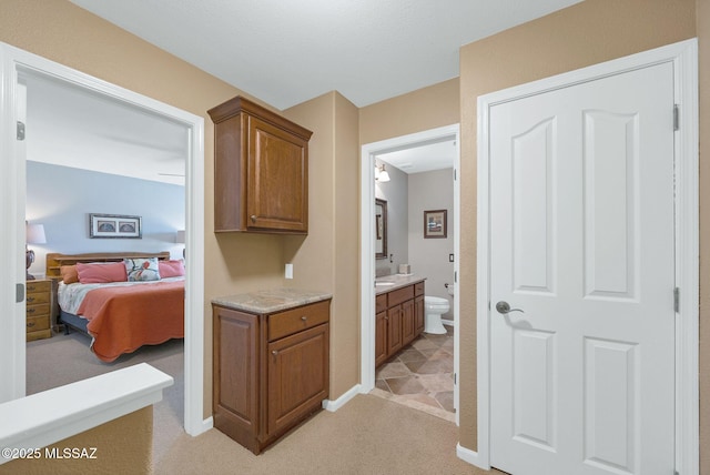 corridor featuring light colored carpet and baseboards