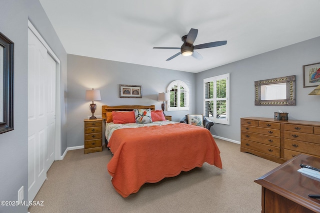 bedroom with ceiling fan, baseboards, carpet flooring, and a closet