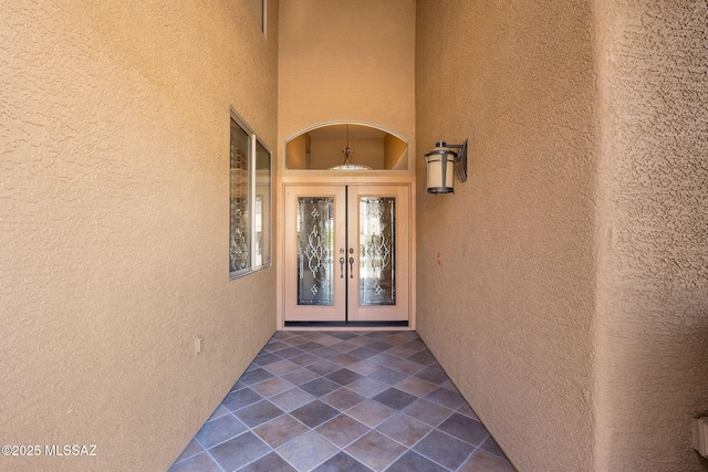 doorway to property featuring french doors and stucco siding