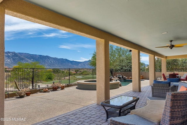 view of patio with a fenced in pool, ceiling fan, a fenced backyard, a mountain view, and an outdoor hangout area