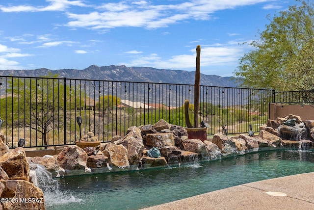 view of pool with a mountain view and fence