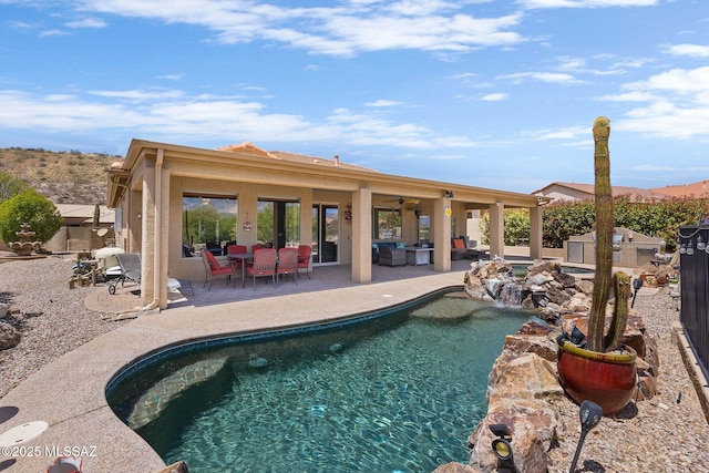 pool with fence, a ceiling fan, and a patio area