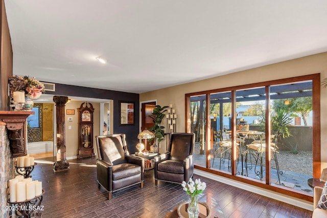 living room with visible vents, baseboards, and wood finished floors