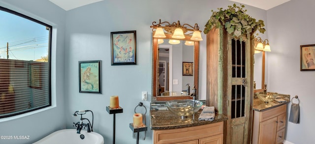 full bathroom with a soaking tub, a sink, and two vanities