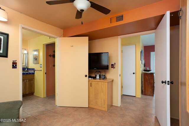 interior space with light tile patterned flooring, visible vents, and a ceiling fan