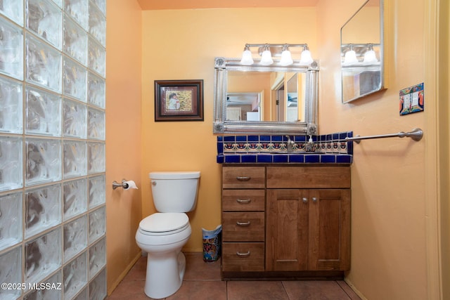 bathroom with tile patterned flooring, vanity, toilet, and baseboards