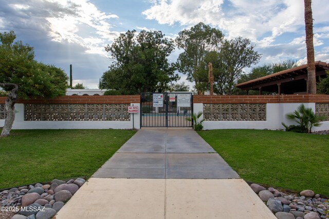 surrounding community featuring driveway, a gate, fence, and a yard
