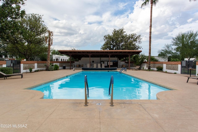 community pool with a patio and fence