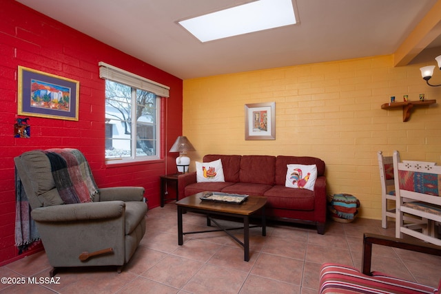 living area with tile patterned flooring and brick wall