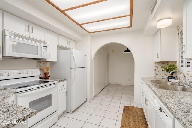 538 N Dodge Blvd, Tucson, AZ 85716 - kitchen featuring white appliances, light tile patterned floors, a sink, arched walkways, and white cabinets